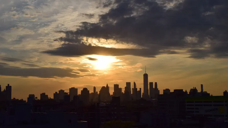 The New York City skyline silhouetted against a sunset sky